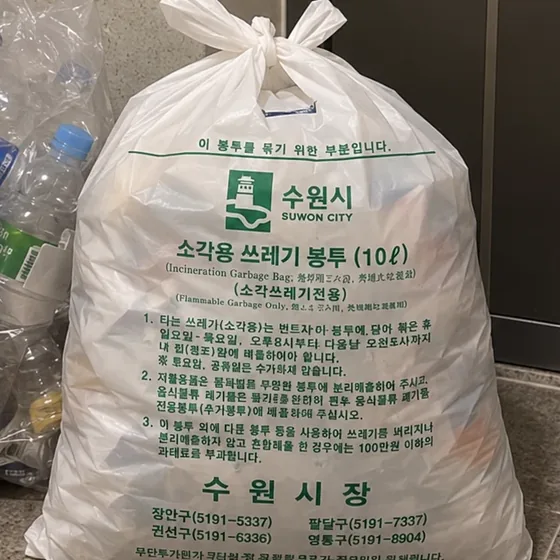 문 앞에 묶어 둔 수원시 종량제봉투